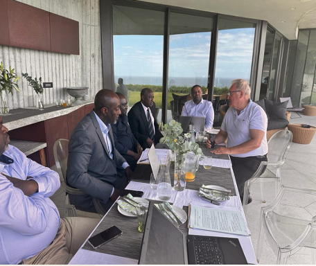 Diverse professionals in a strategic business meeting in a modern outdoor setting by the ocean